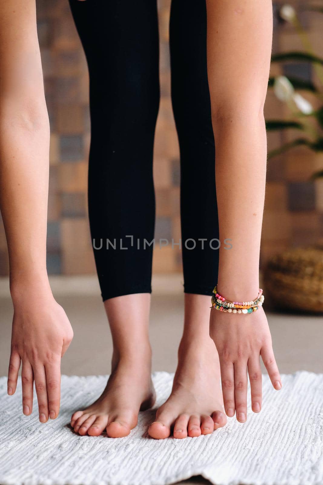 Close-up of a young woman in black clothes doing yoga in a modern gym.The concept of health.