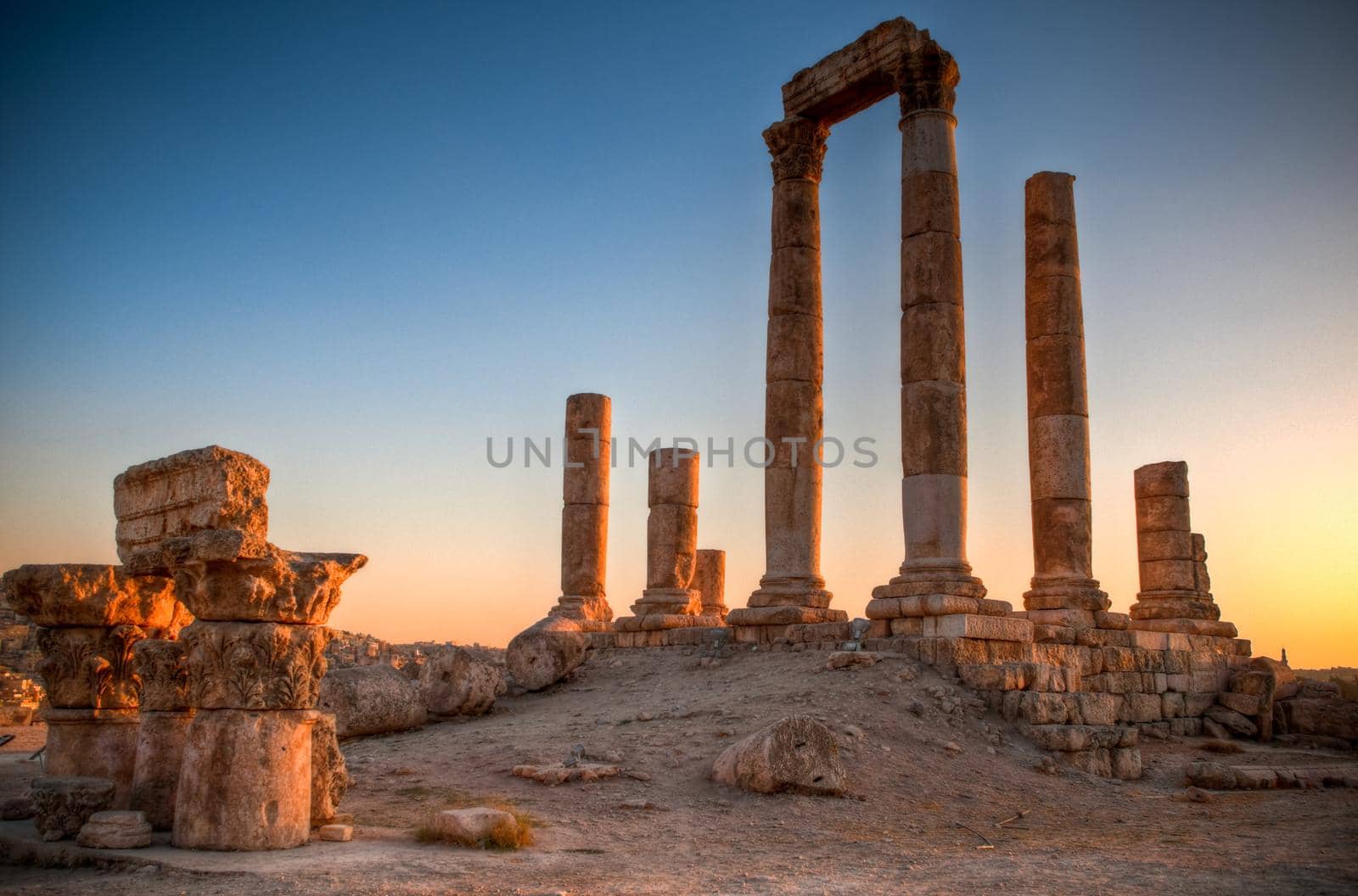 ancient ruins with sun and sunset sky in background (Temple of Hercules in Amman, Jordan)