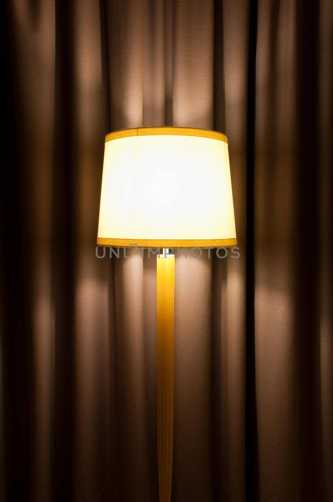 cozy interior with lamp on stand against curtain