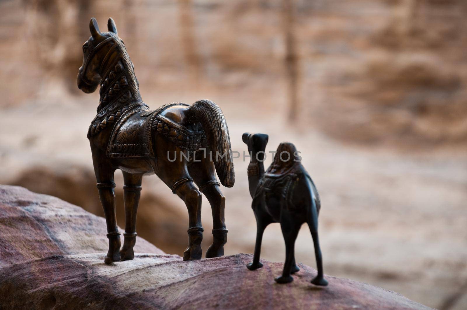 iron figurine of camel and horse with mountains in background