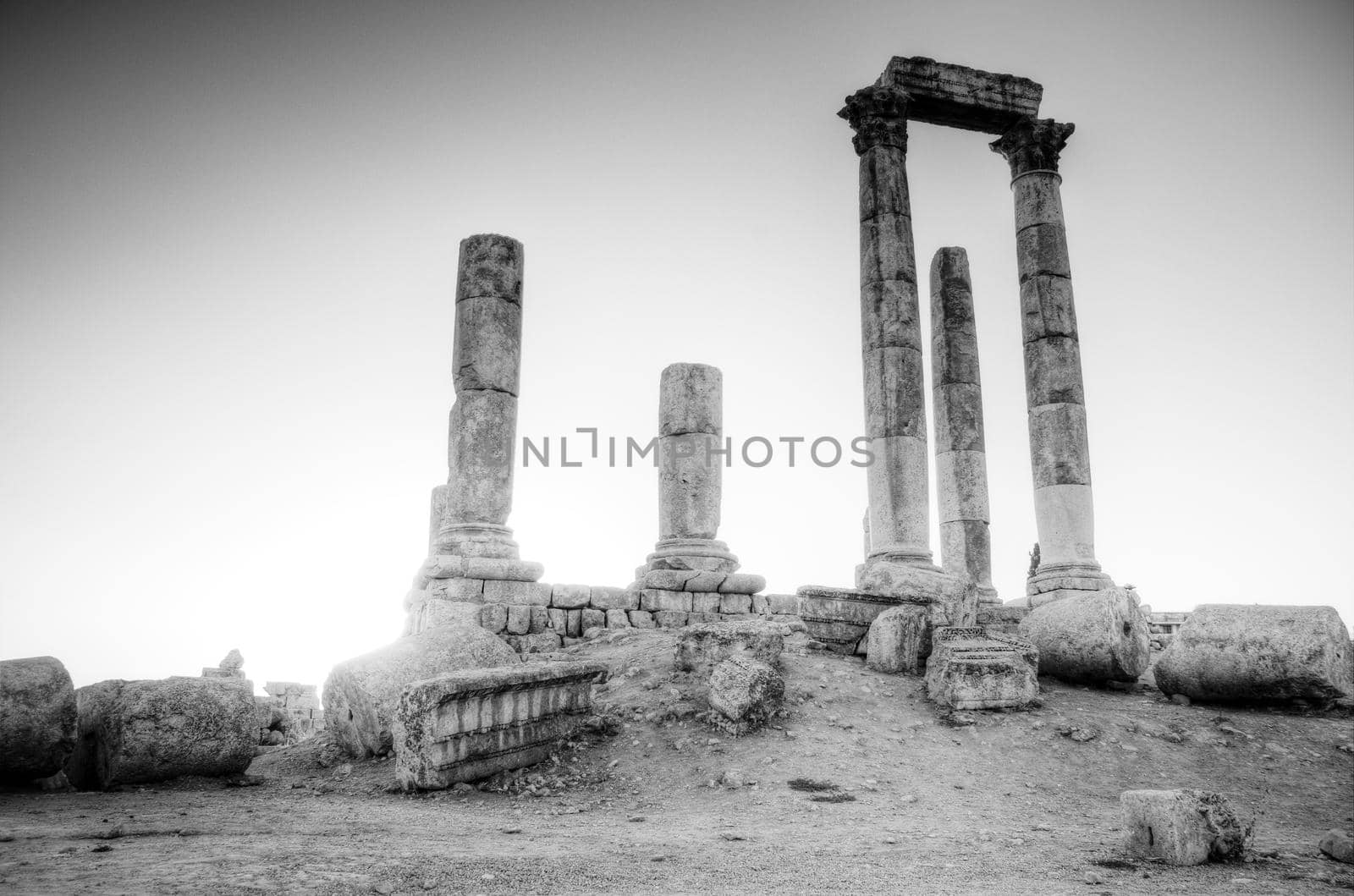 ancient ruins with sun and sunset sky in background (Temple of Hercules in Amman, Jordan)