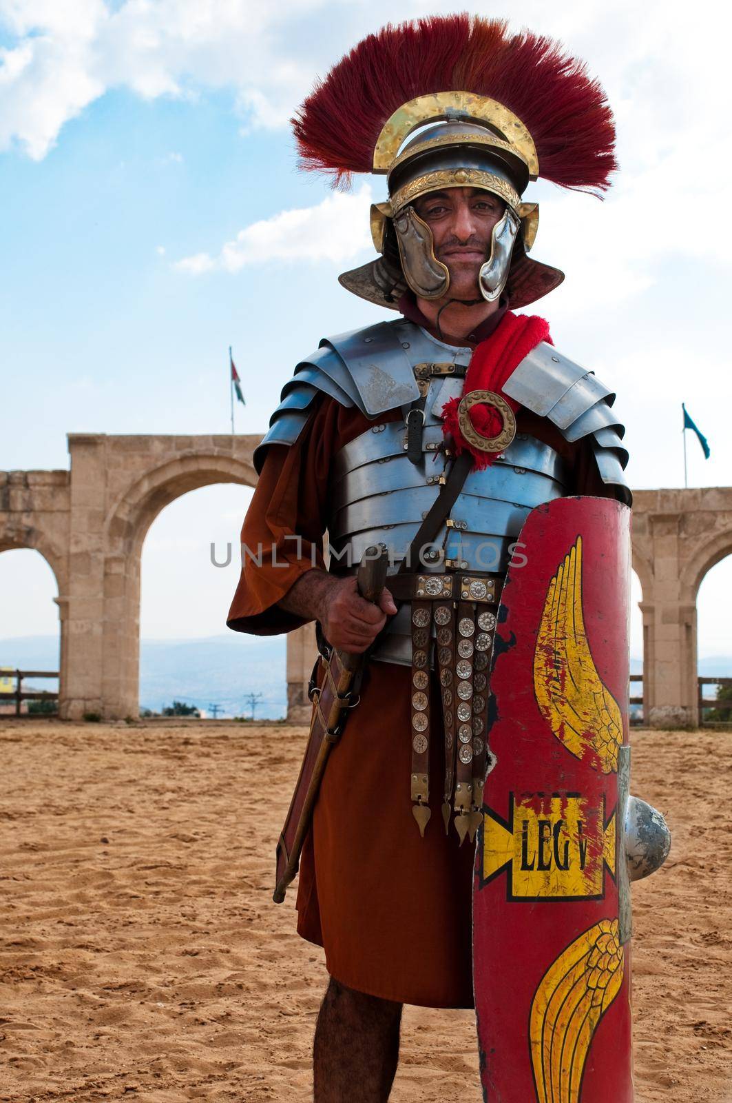 high ranked roman warrior standing on the sand in the walls of ancient town