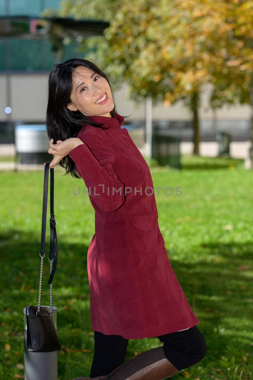 Beautiful chinese woman with long black hair on a sunny autumn day in the city,