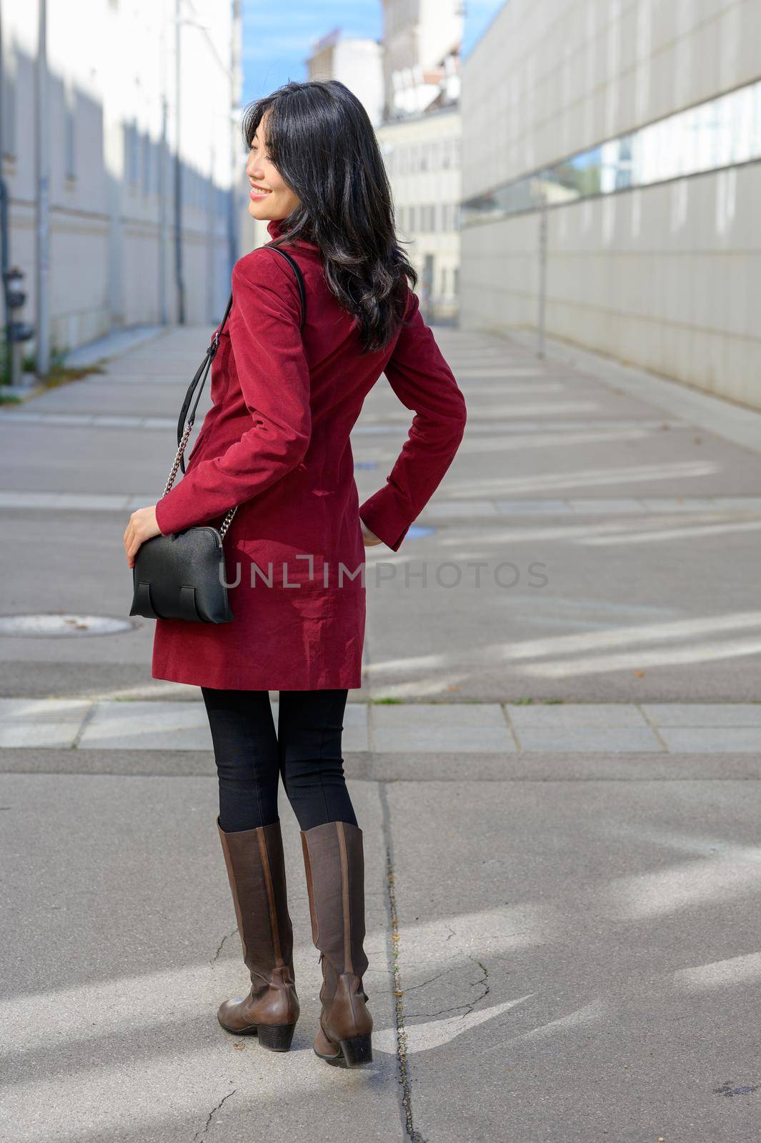 Beautiful chinese woman with long black hair on a sunny autumn day in the city,