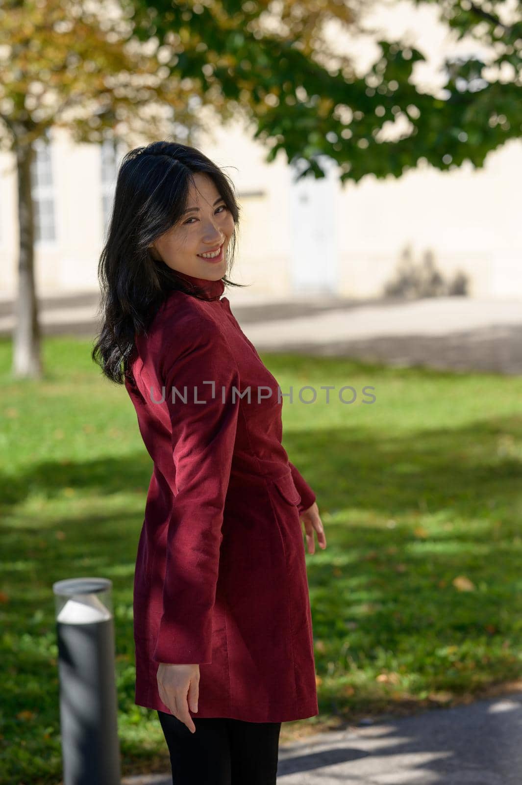 Beautiful chinese woman with long black hair on a sunny autumn day in the city,