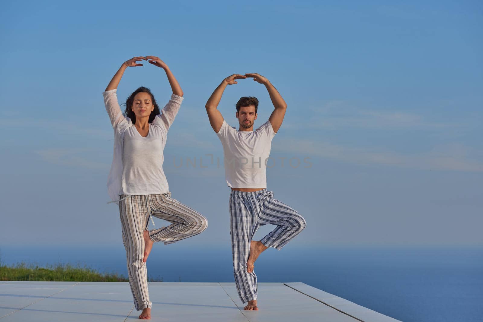 young couple practicing yoga by dotshock