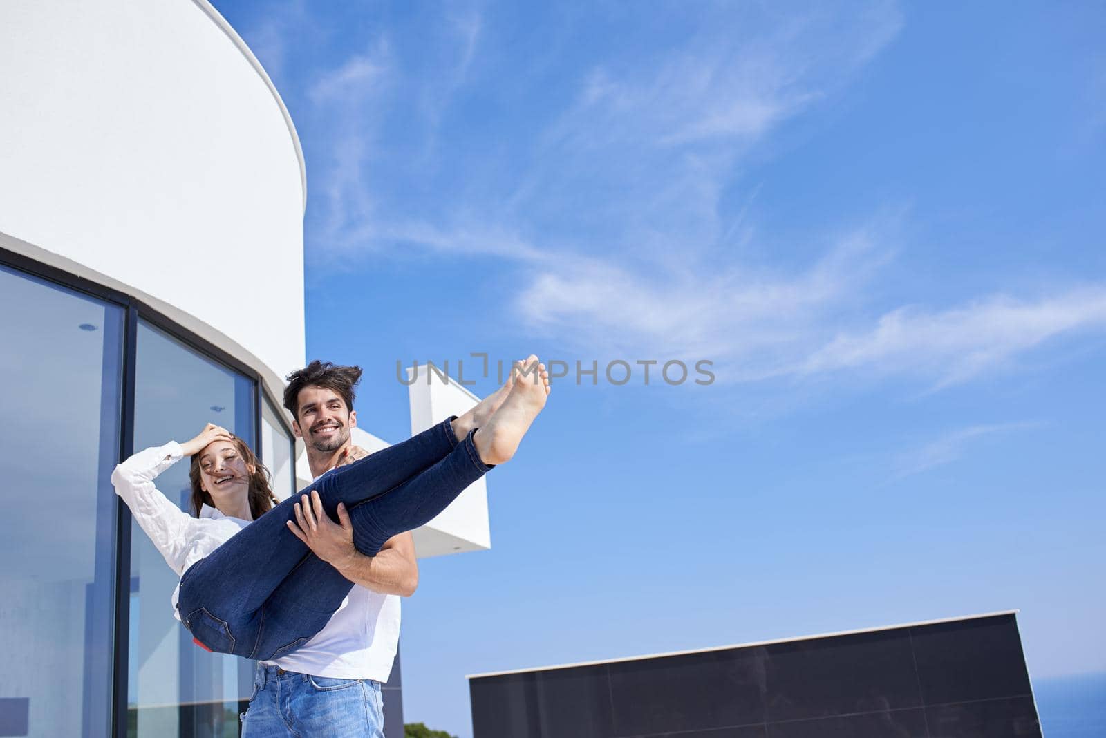 happy young romantic couple have fun relax smile at modern home outdoor terace balcony terace