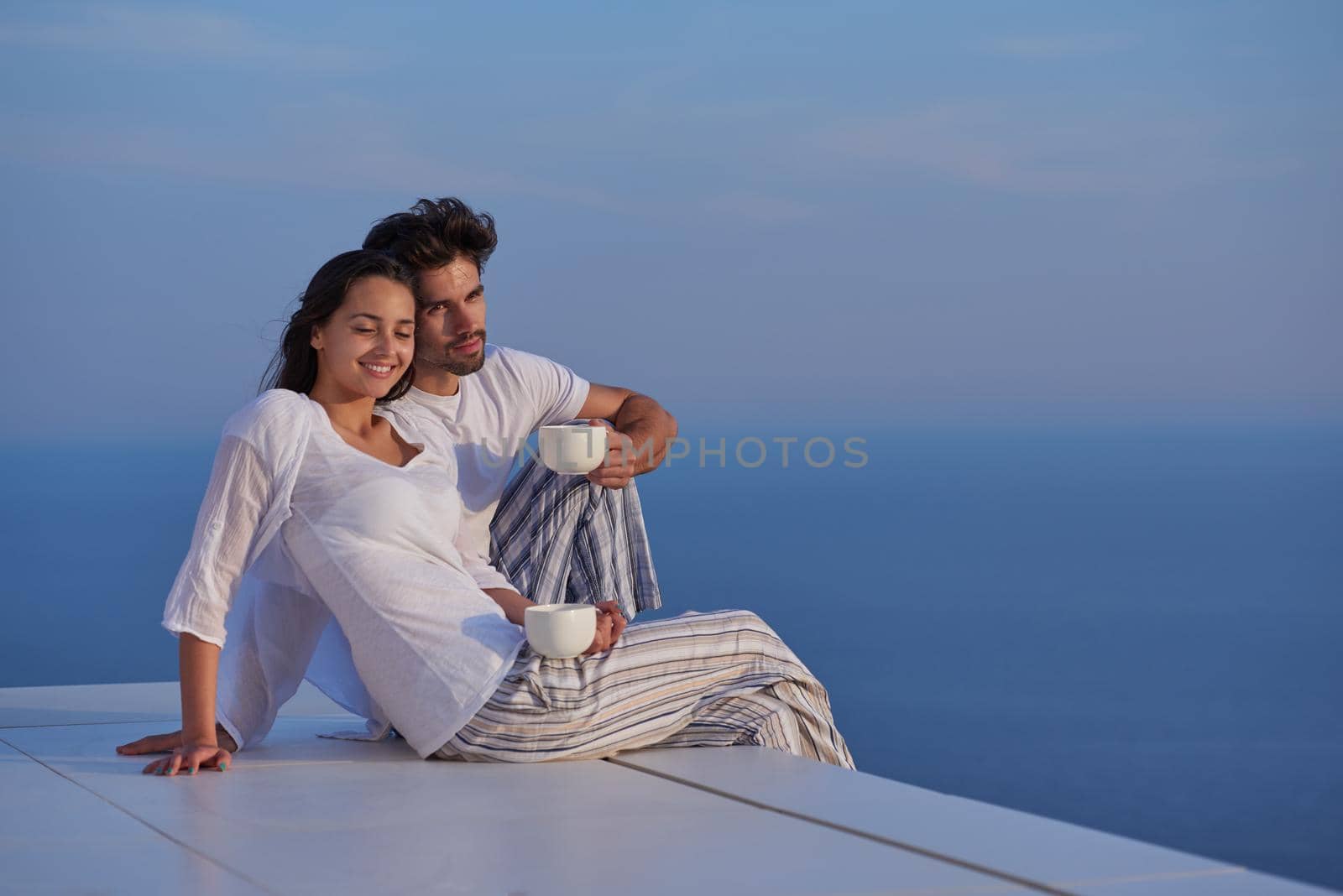 happy young romantic couple have fun relax smile at modern home outdoor terace balcony terace