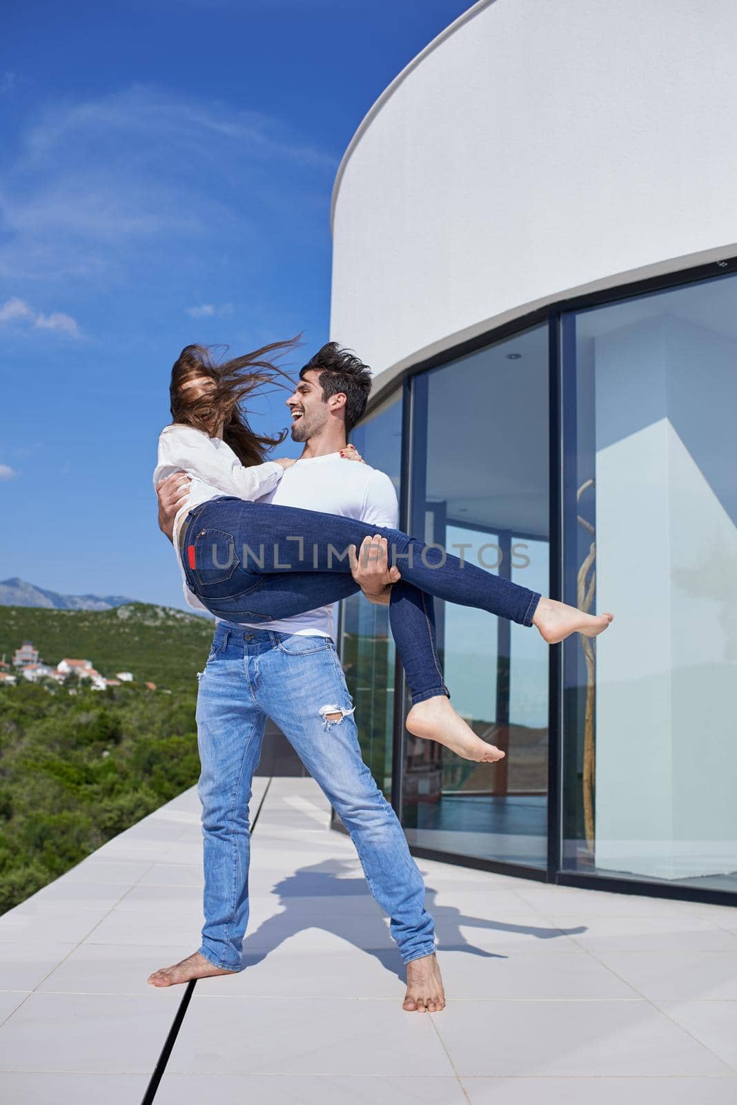 happy young romantic couple have fun relax smile at modern home outdoor terace balcony terace