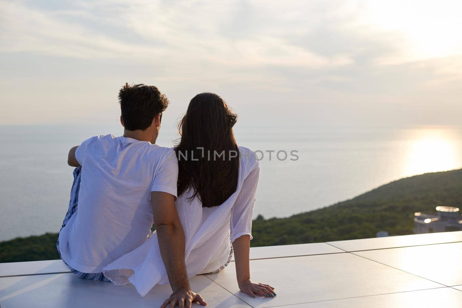 happy young romantic couple have fun relax smile at modern home outdoor terace balcony