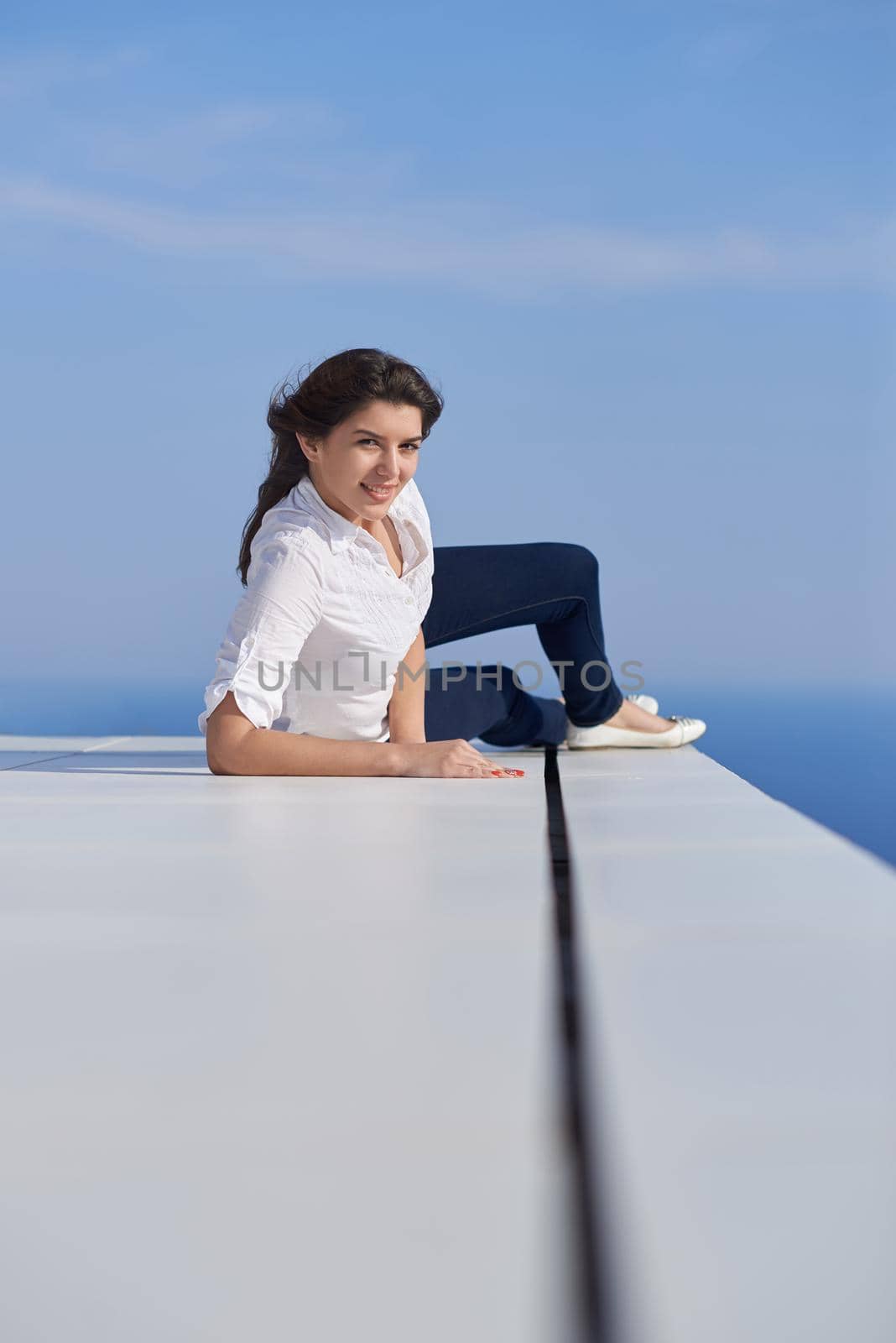 relaxed young beautiful woman in front of luxury modern home villa  on balcony on sunny day