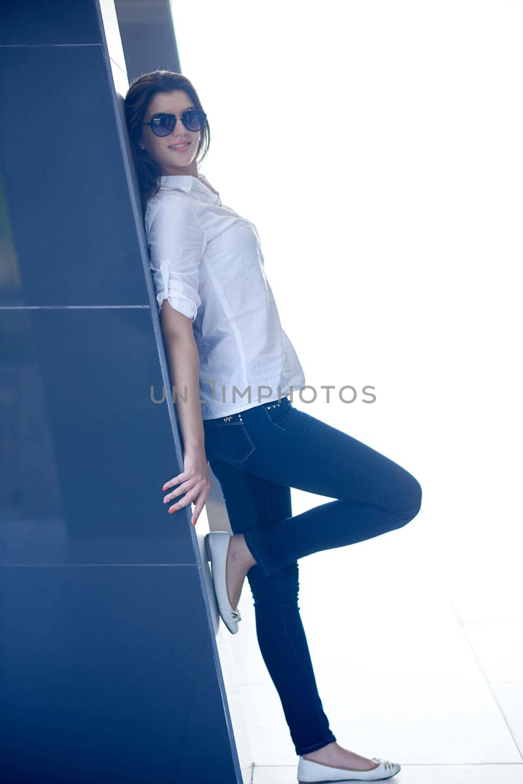 relaxed woman in front of luxury modern home by dotshock