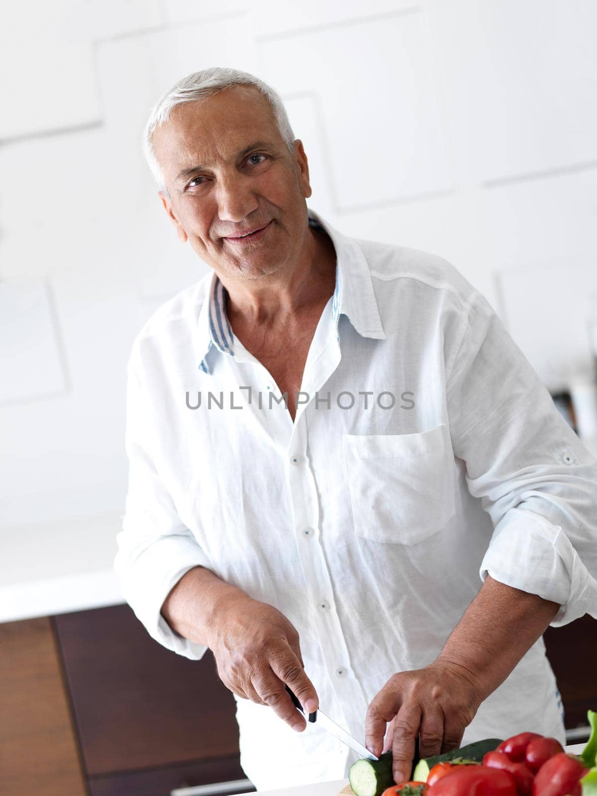 man cooking at home preparing salad in kitchen by dotshock