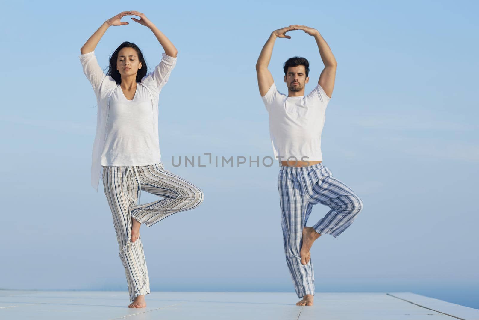 young couple practicing yoga by dotshock