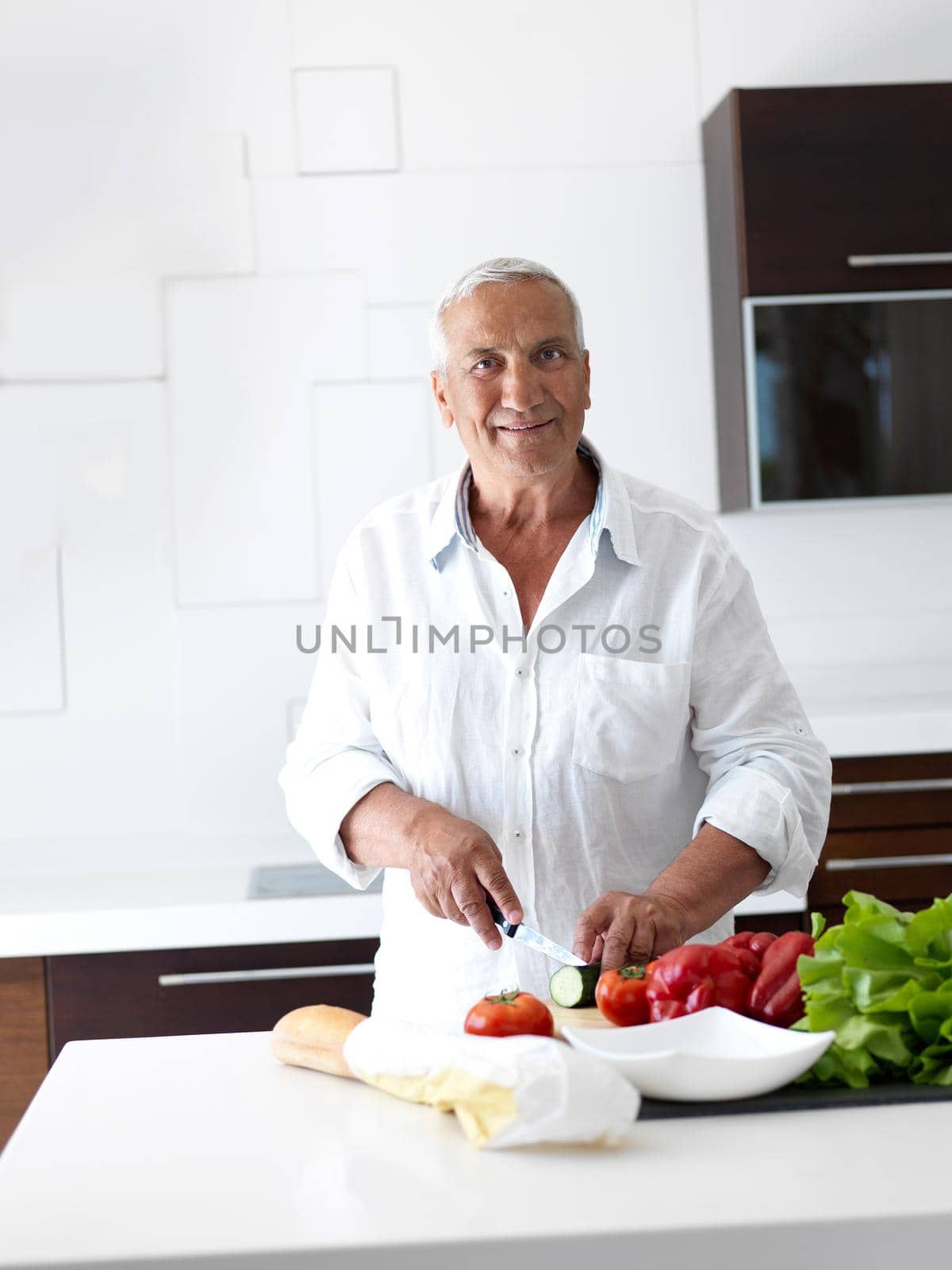 man cooking at home preparing salad in kitchen by dotshock