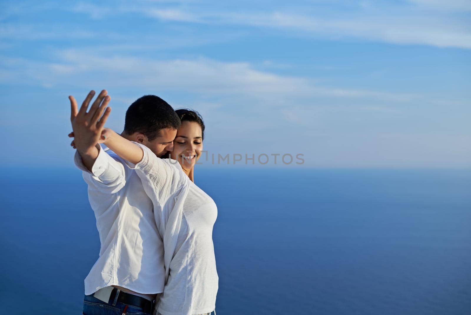 happy young romantic couple have fun relax smile at modern home outdoor terace balcony