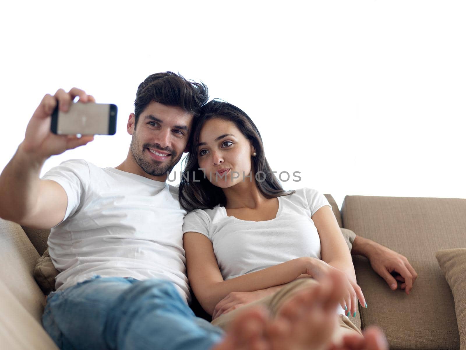 cheerful happy young couple making selfie together at home