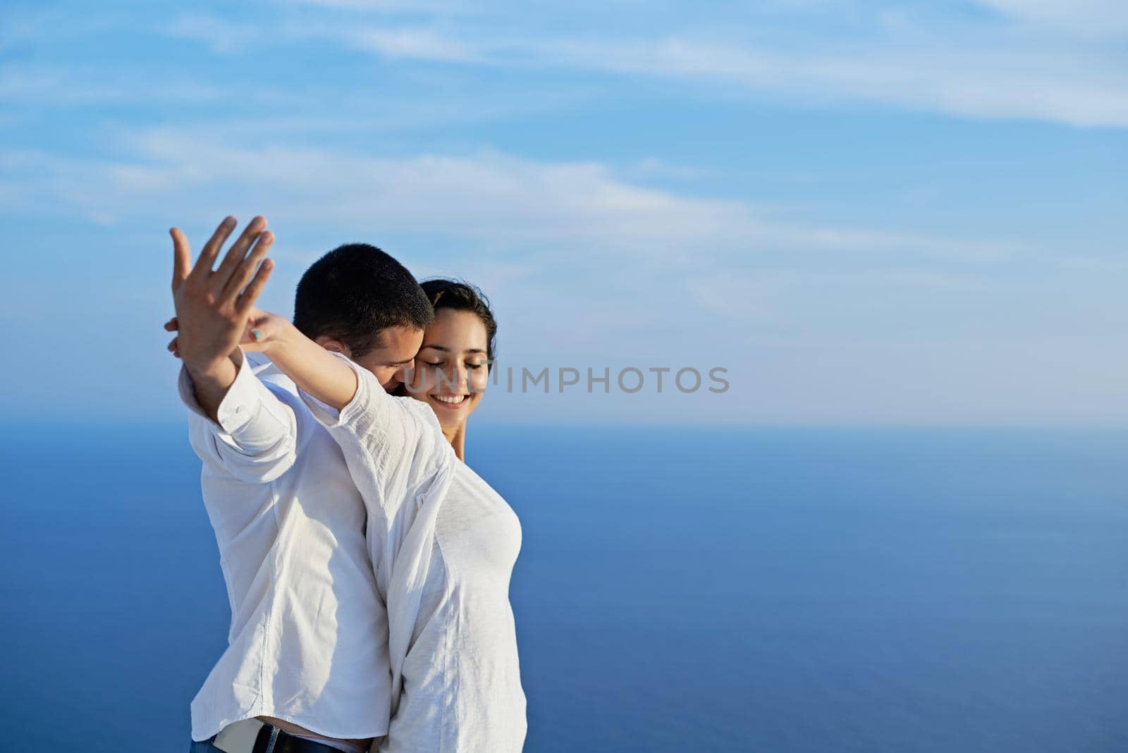 happy young romantic couple have fun relax smile at modern home outdoor terace balcony