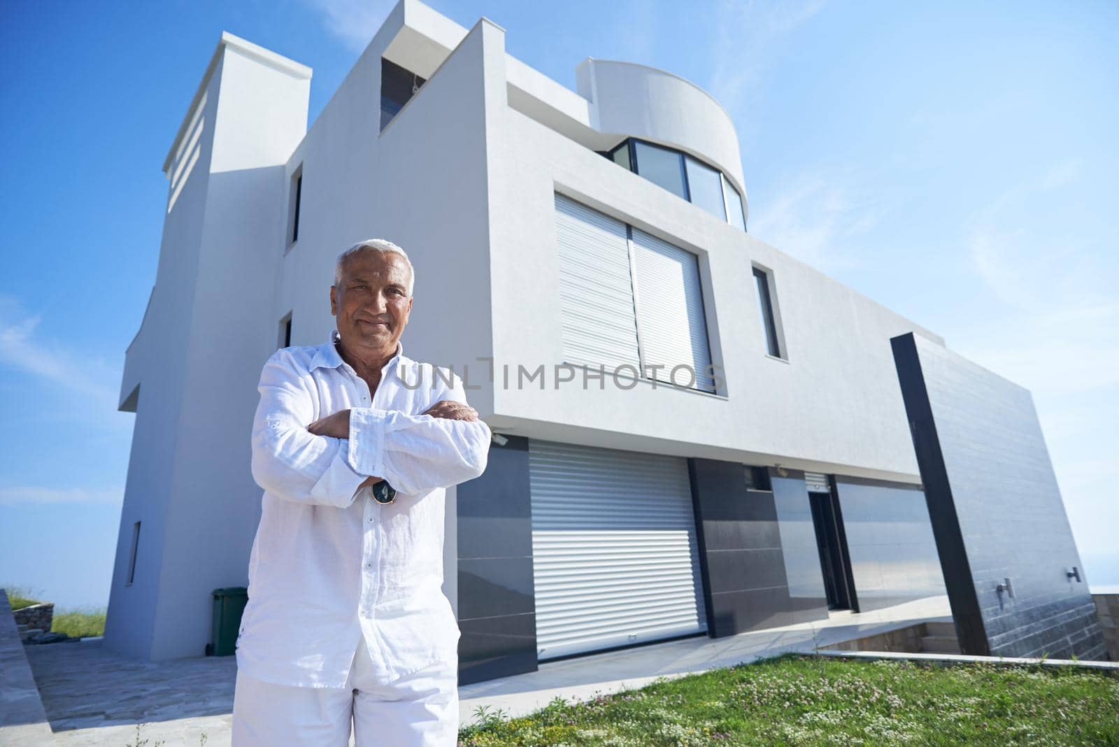 senior man in front of luxury modern home villa