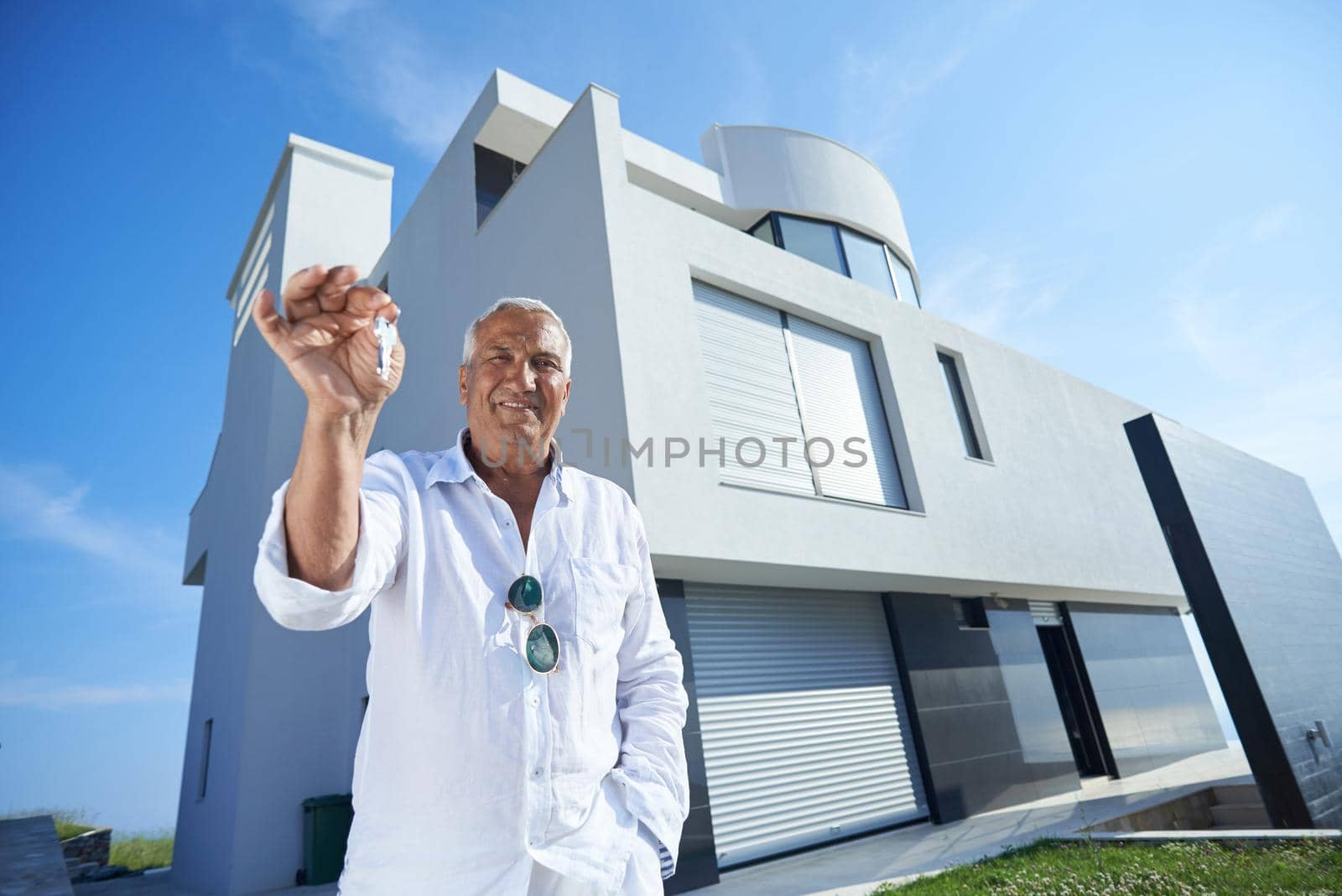 senior man in front of modern home by dotshock