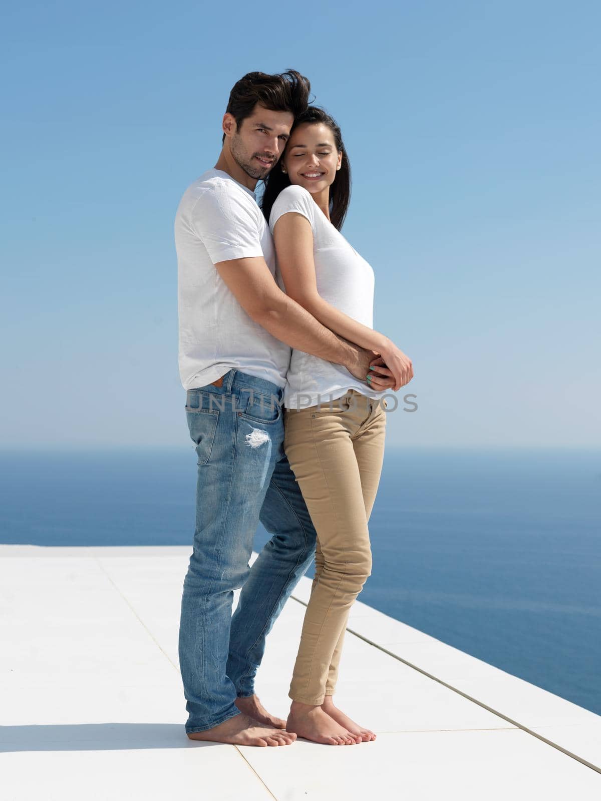 happy young romantic couple have fun relax smile at modern home outdoor terace balcony terace