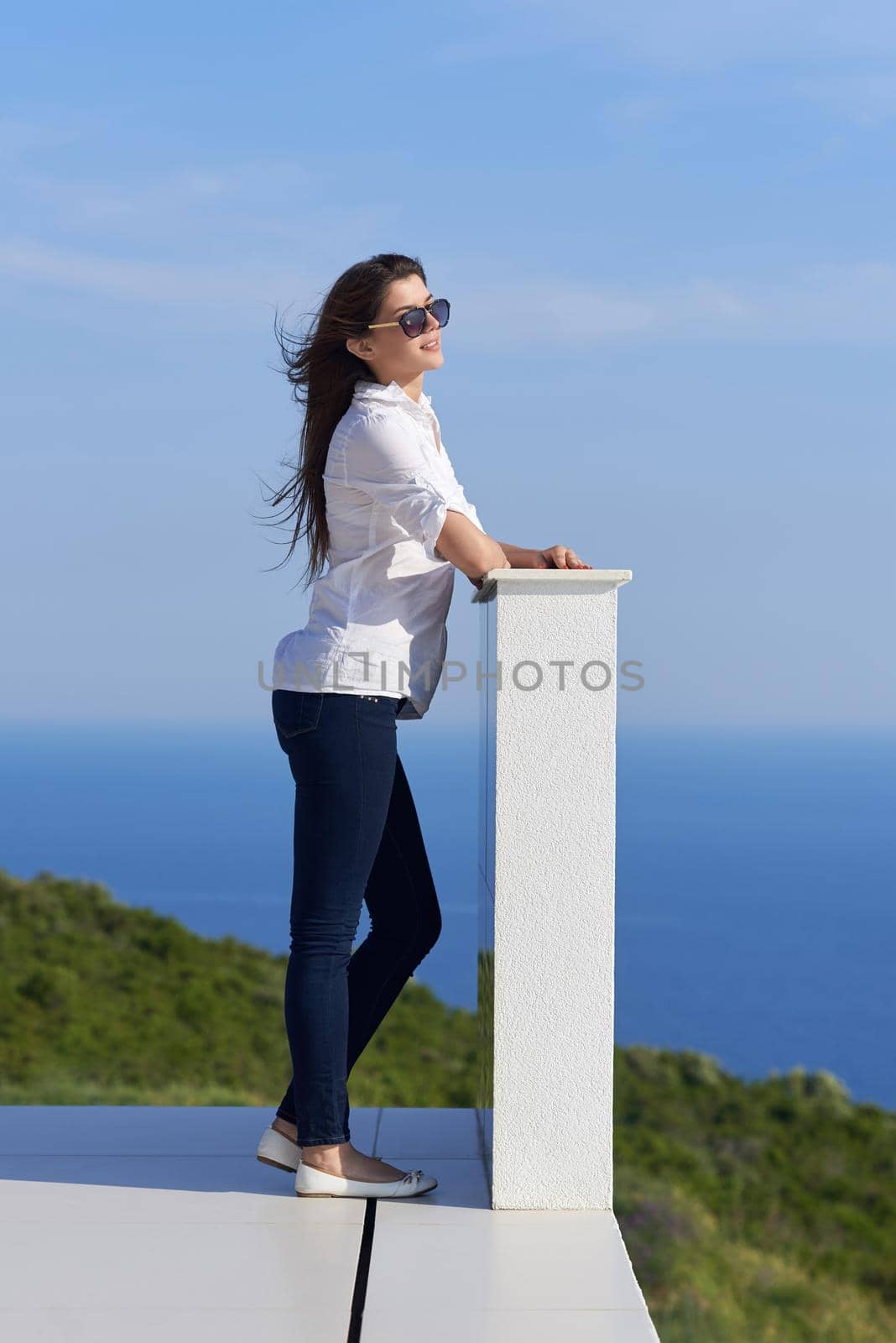 relaxed woman in front of luxury modern home by dotshock