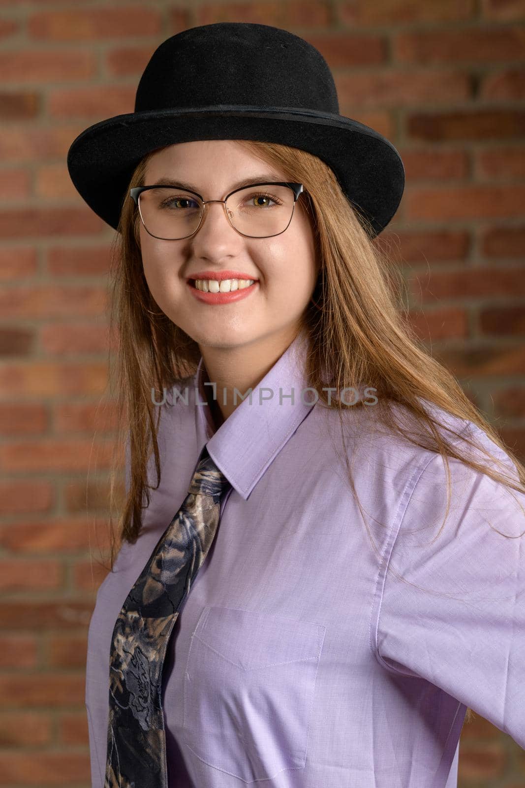 A beautiful young woman with long blond hairs in typically mens outfit.