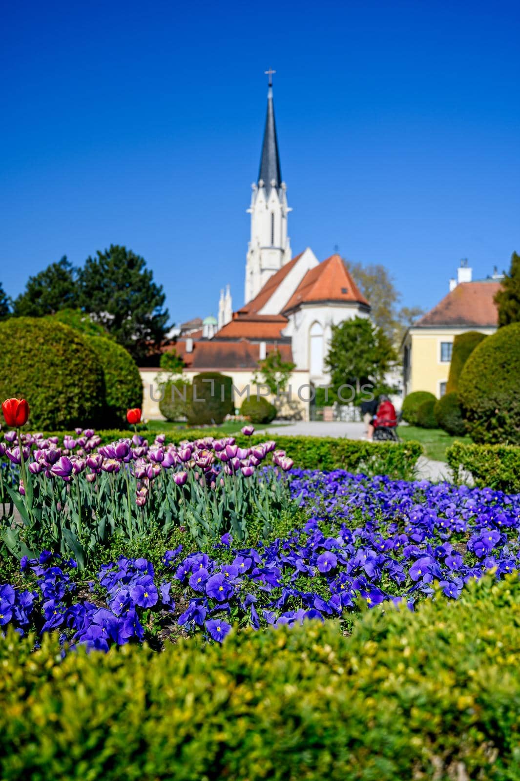 A beautiful well-tended flowerbed with a church in the background.