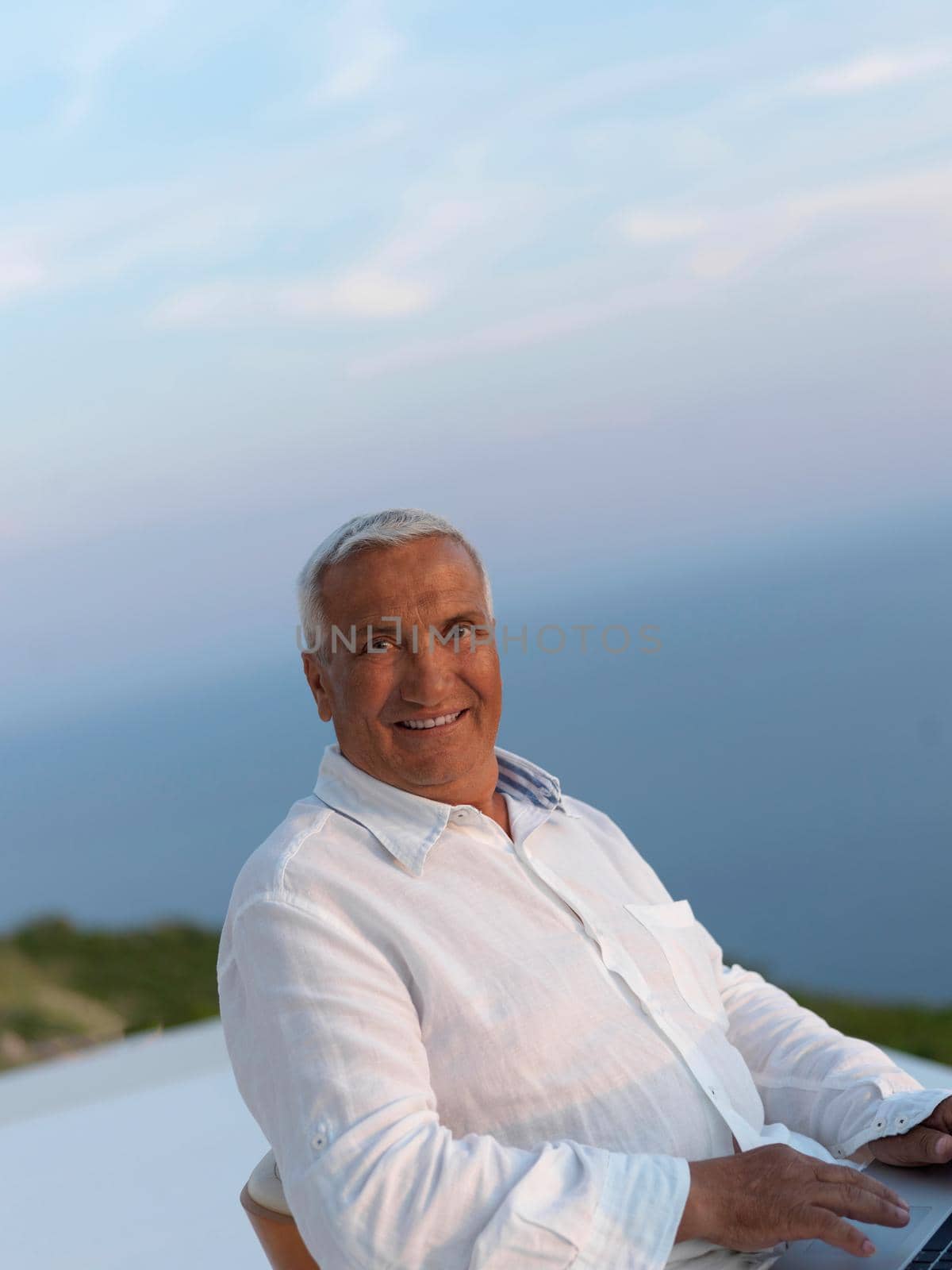 relaxed senior man on balcony by dotshock