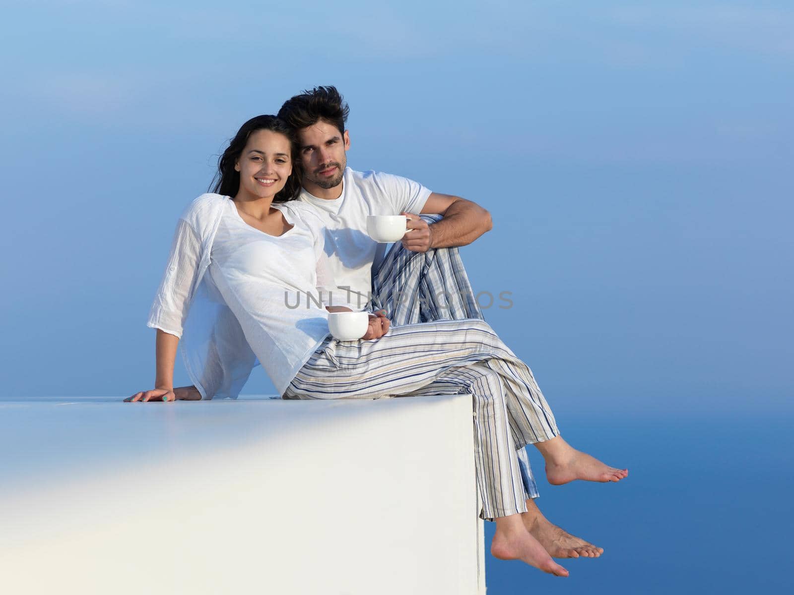 happy young romantic couple have fun relax smile at modern home outdoor terace balcony terace