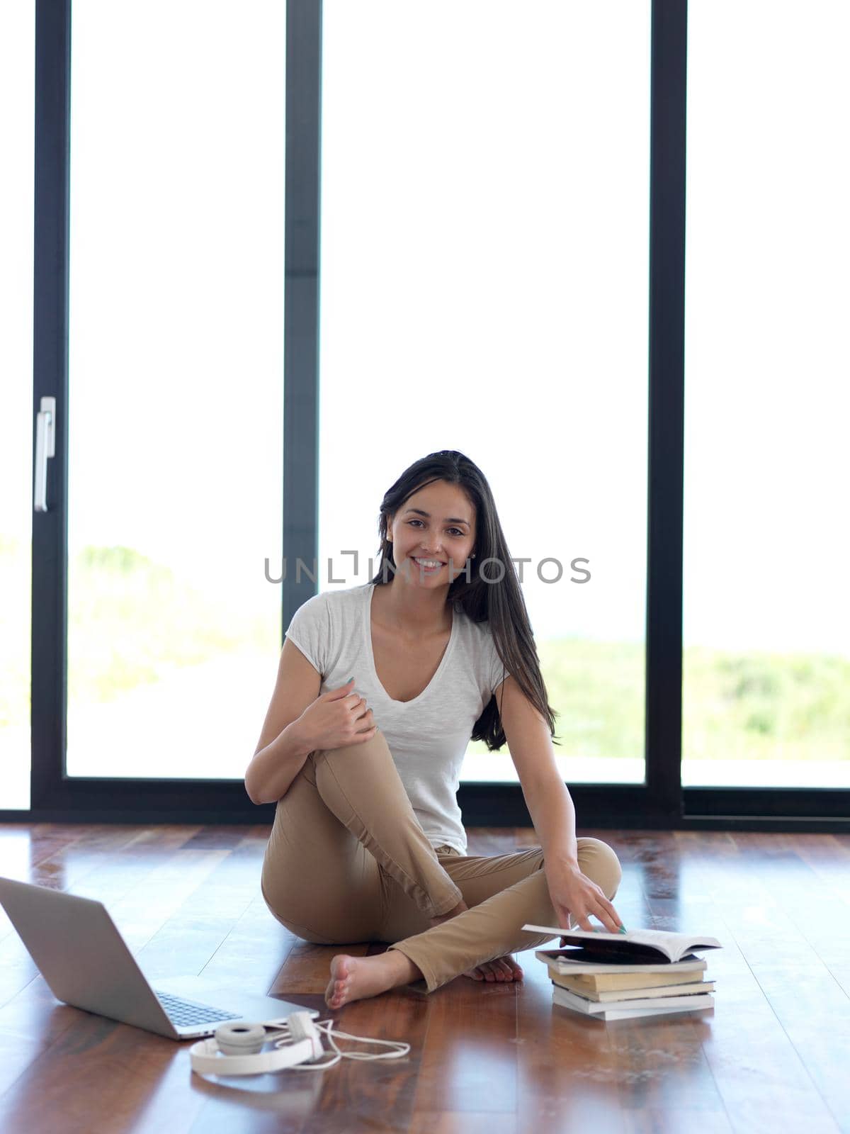 relaxed young woman at home working on laptop computer by dotshock