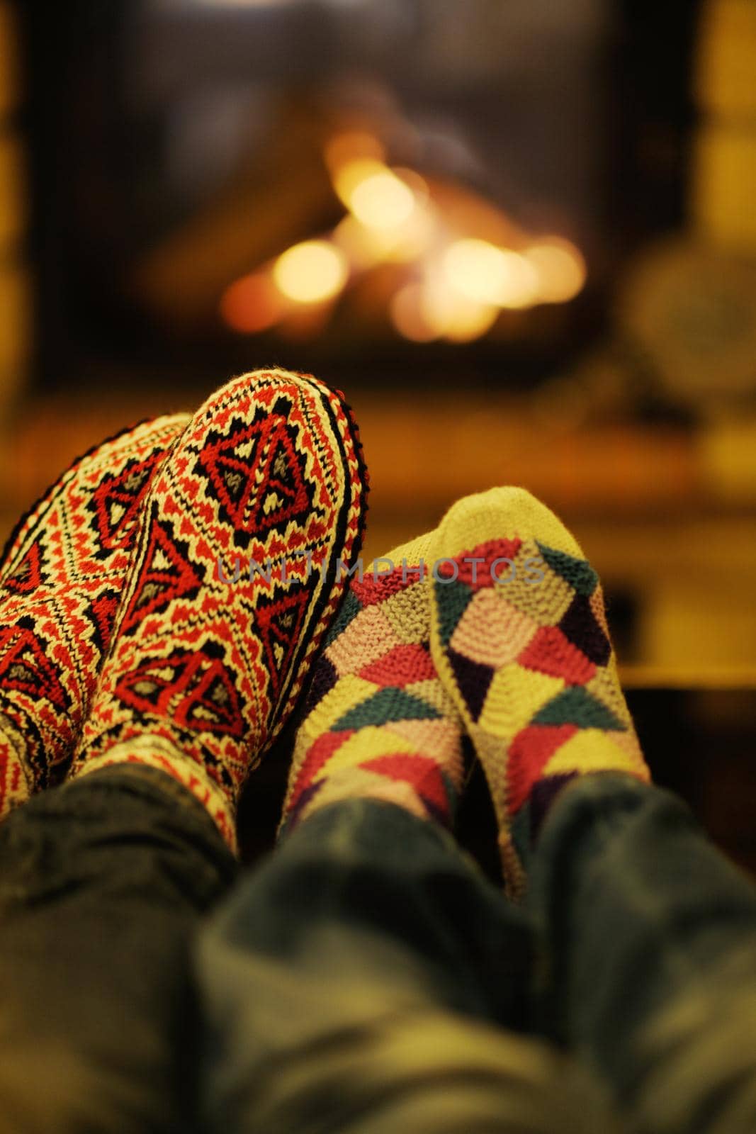 Young romantic couple relax on sofa in front of fireplace at home by dotshock