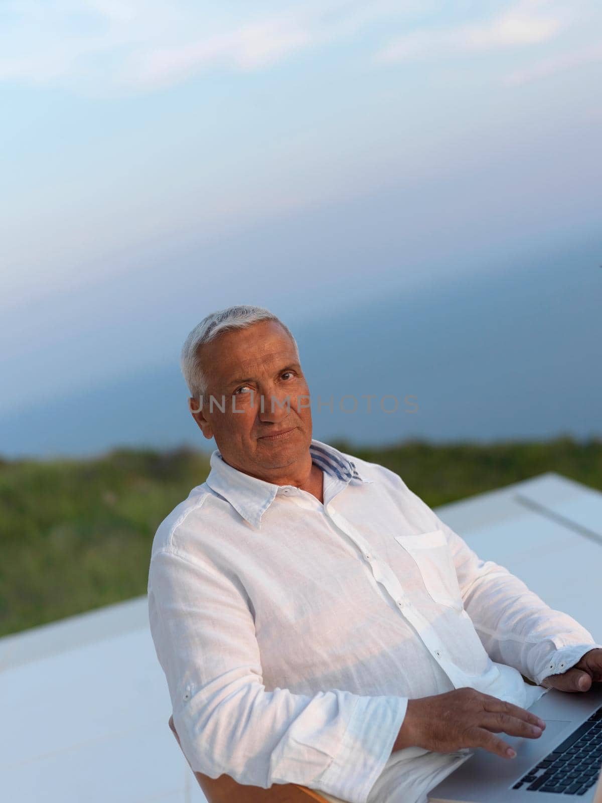 relaxed senior man on balcony by dotshock