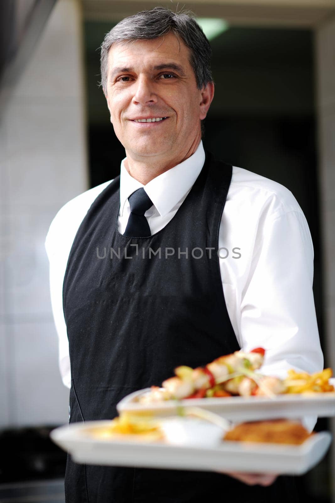 male chef presenting food meal in kitchen