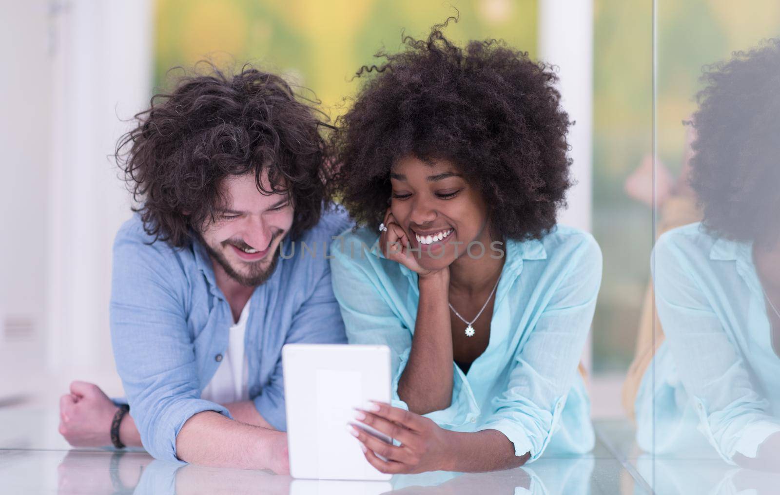 Couple relaxing together at home with tablet computer by dotshock