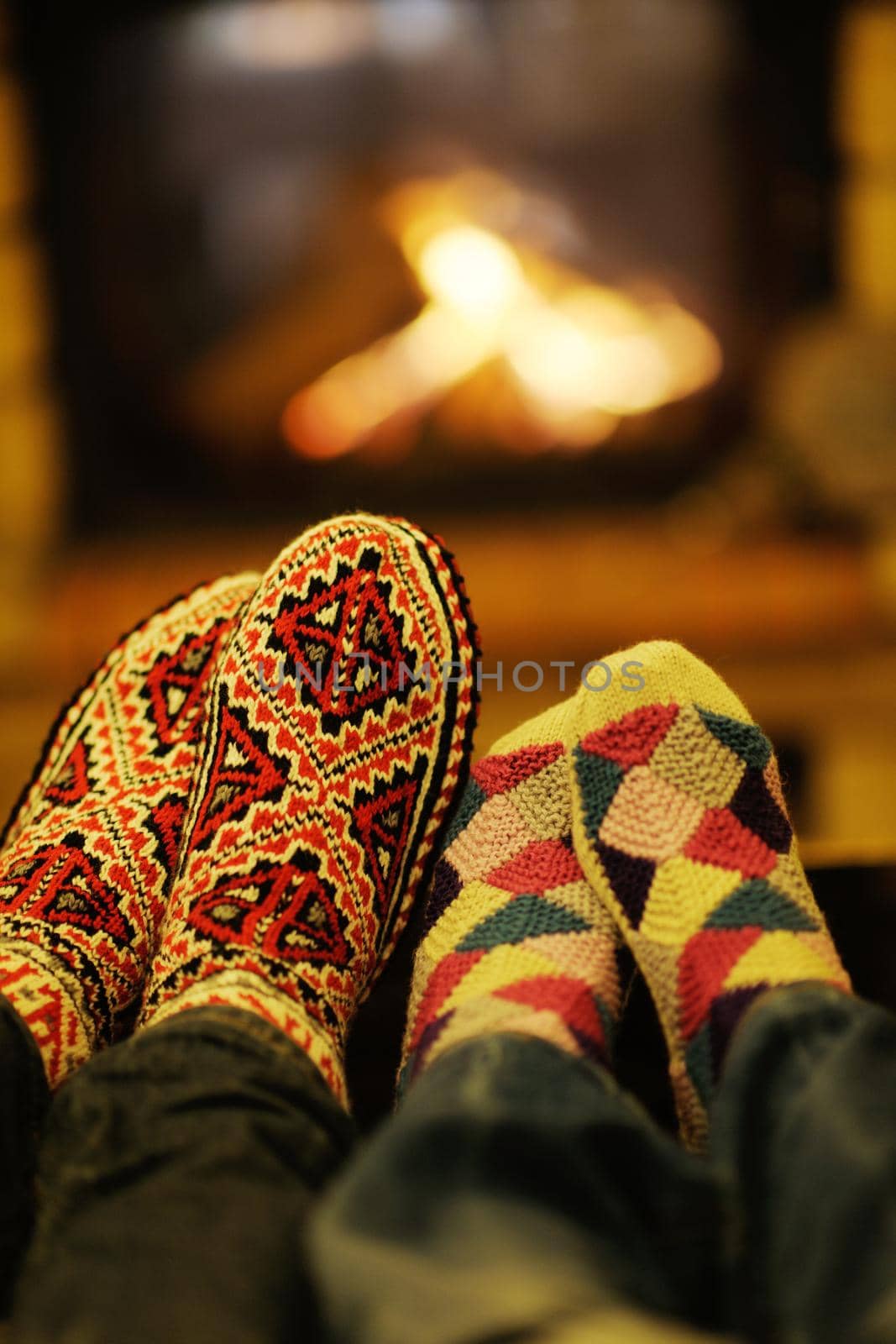 Young romantic couple relax on sofa in front of fireplace at home by dotshock