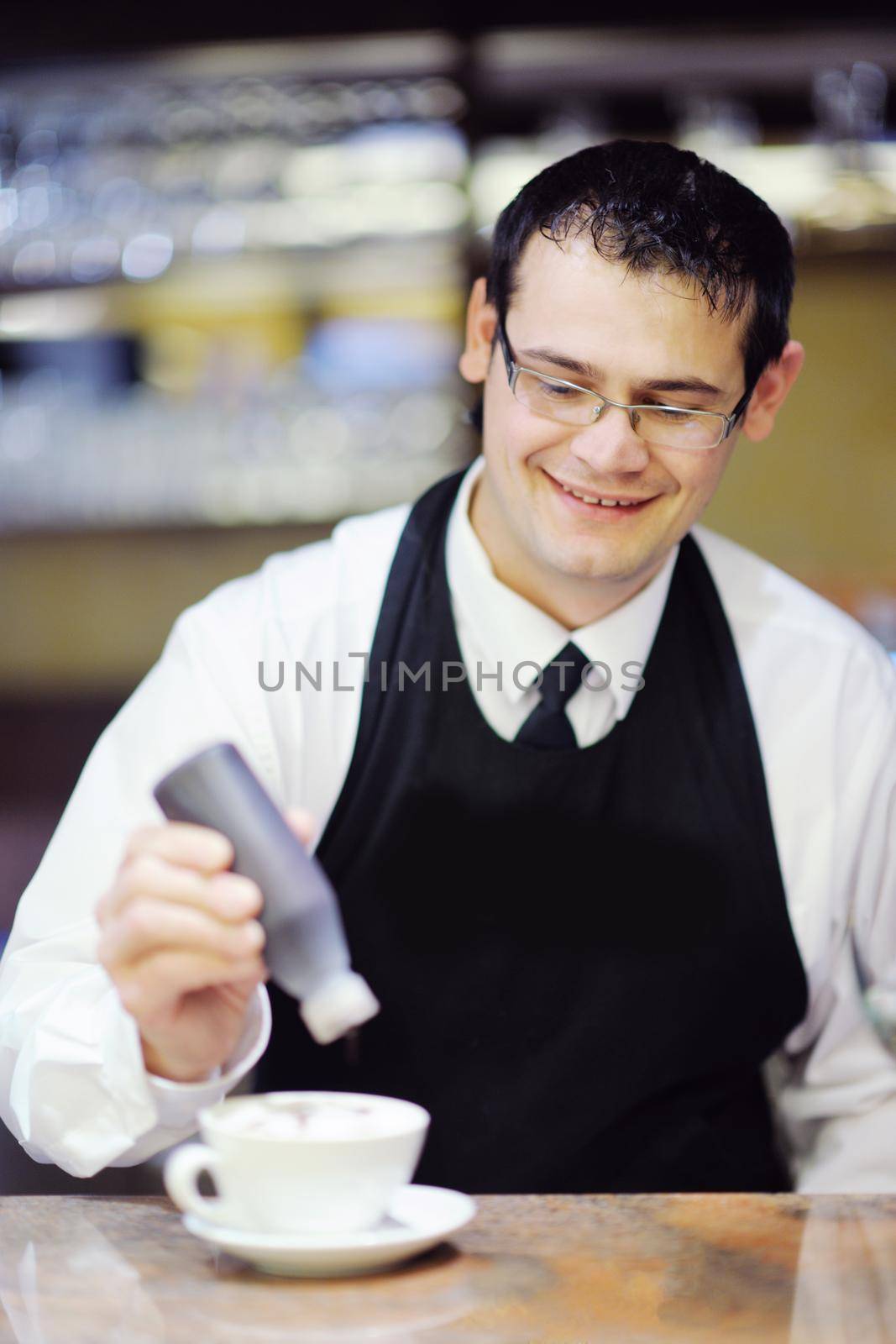 Barista prepares cappuccino in his coffee shop