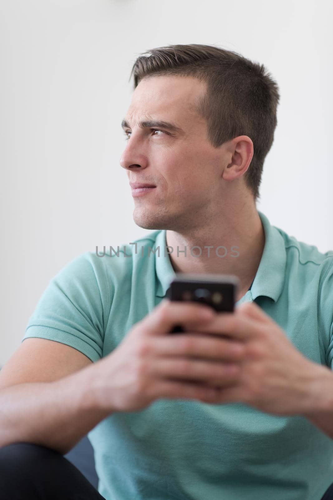 Handsome casual young man using a mobile phone at luxurious home