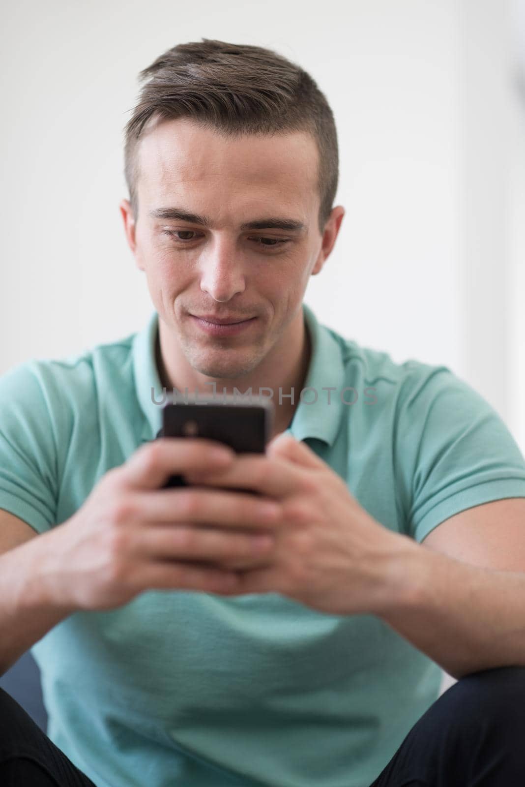 young man using a mobile phone  at home by dotshock