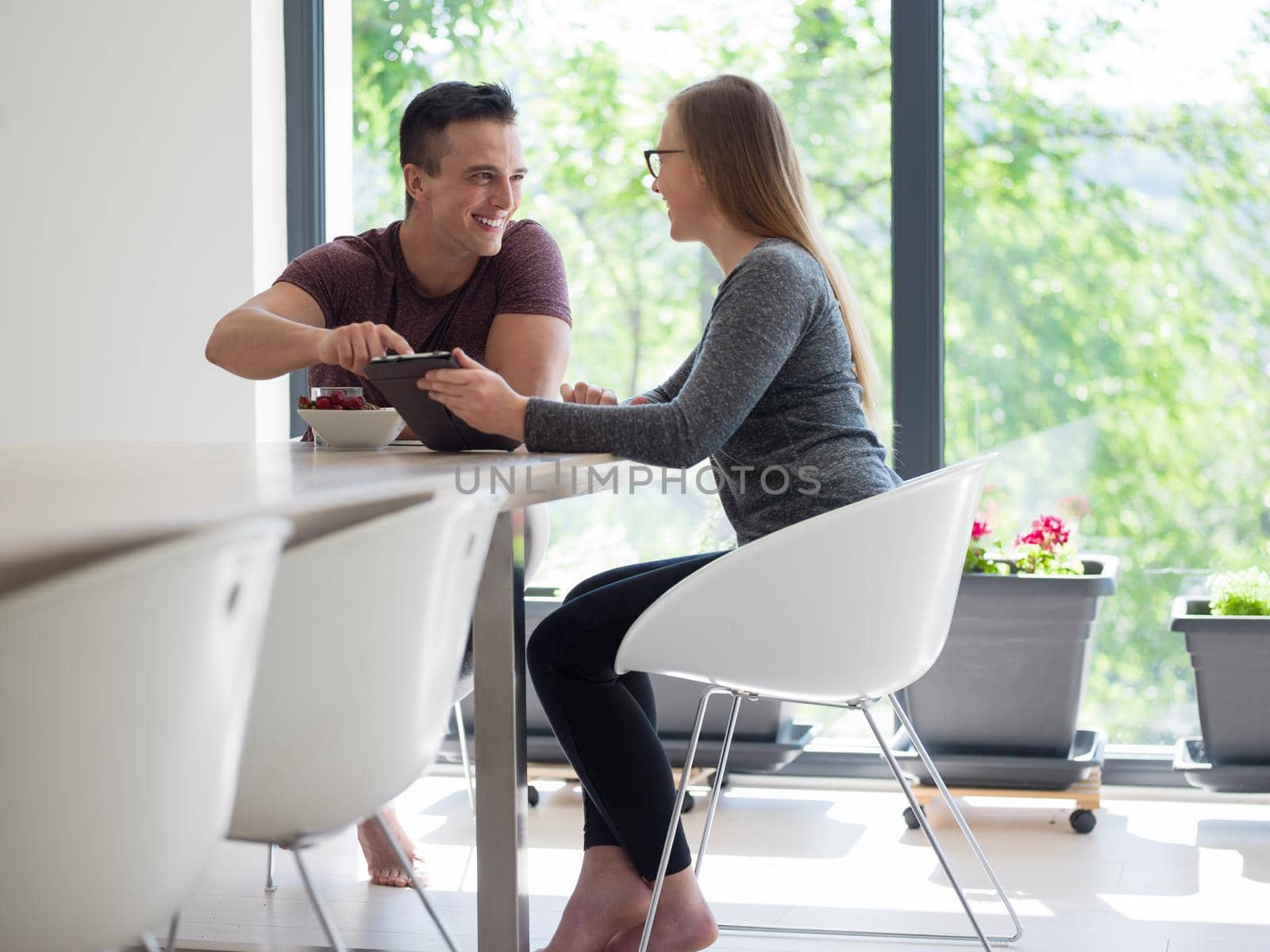 young beautiful handsome couple enjoying morning coffee and strawberries in their luxurious home villa