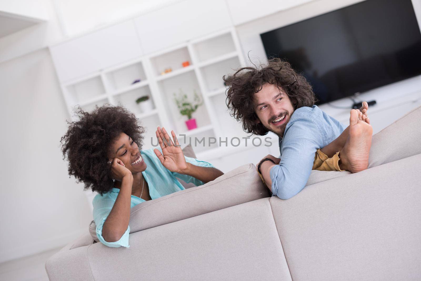 Young multiethnic couple sitting on a sofa in the luxury living room