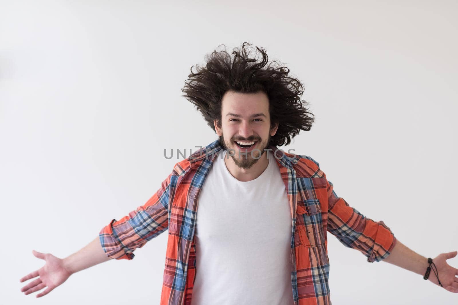 Portrait of an excited casual man standing with open arms and looking at camera isolated on a white background