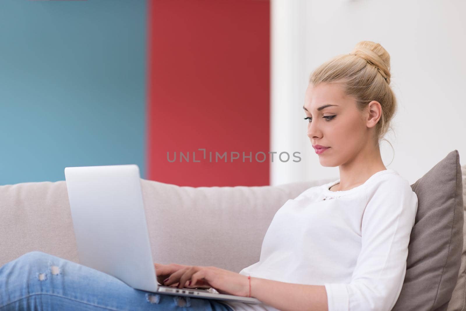 Young woman using laptop at home by dotshock