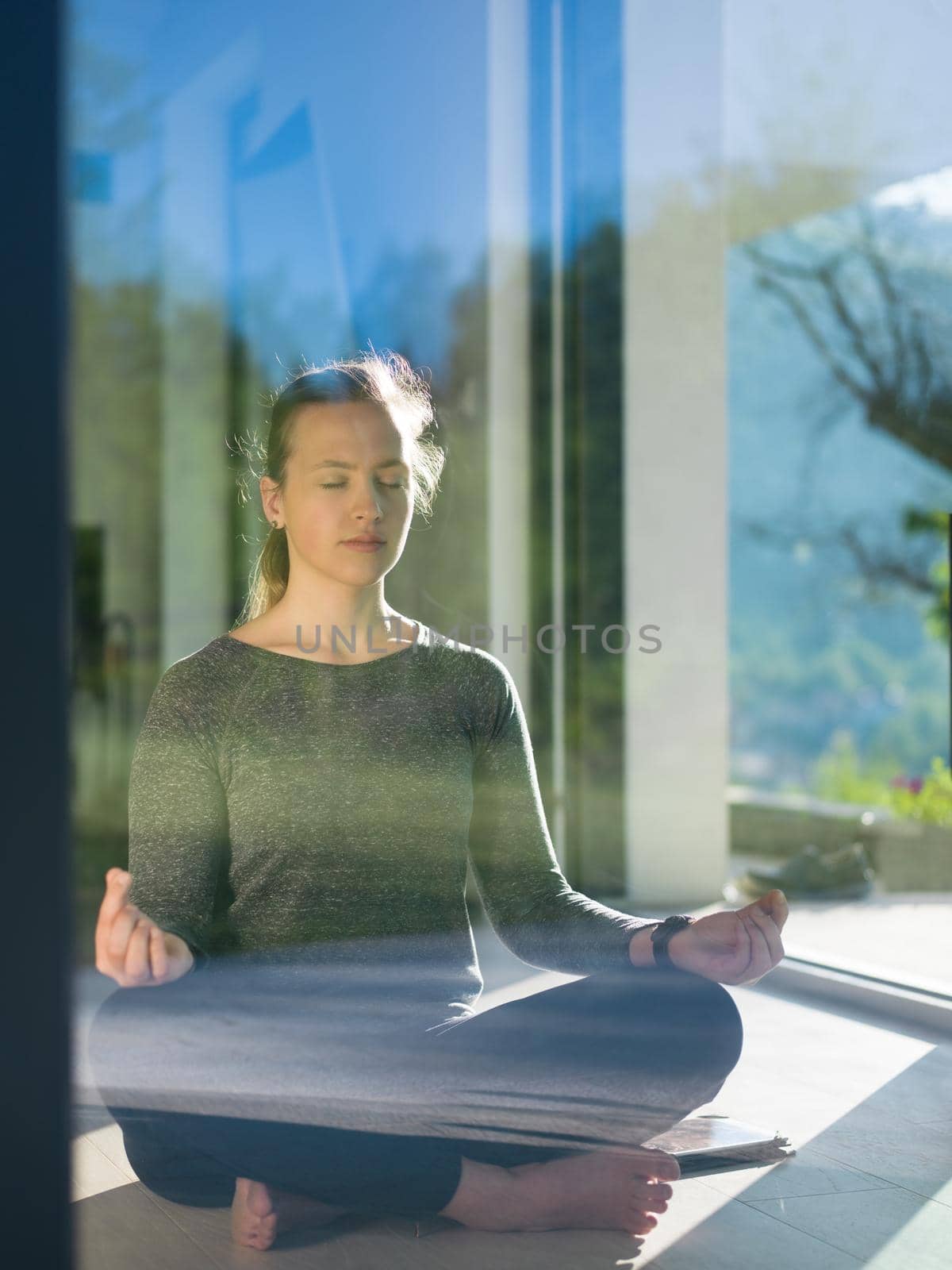 A young handsome woman doing yoga exercises on the floor of her luxury home villa