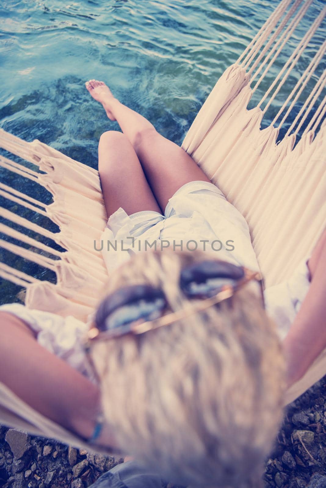 blonde woman resting on hammock by dotshock