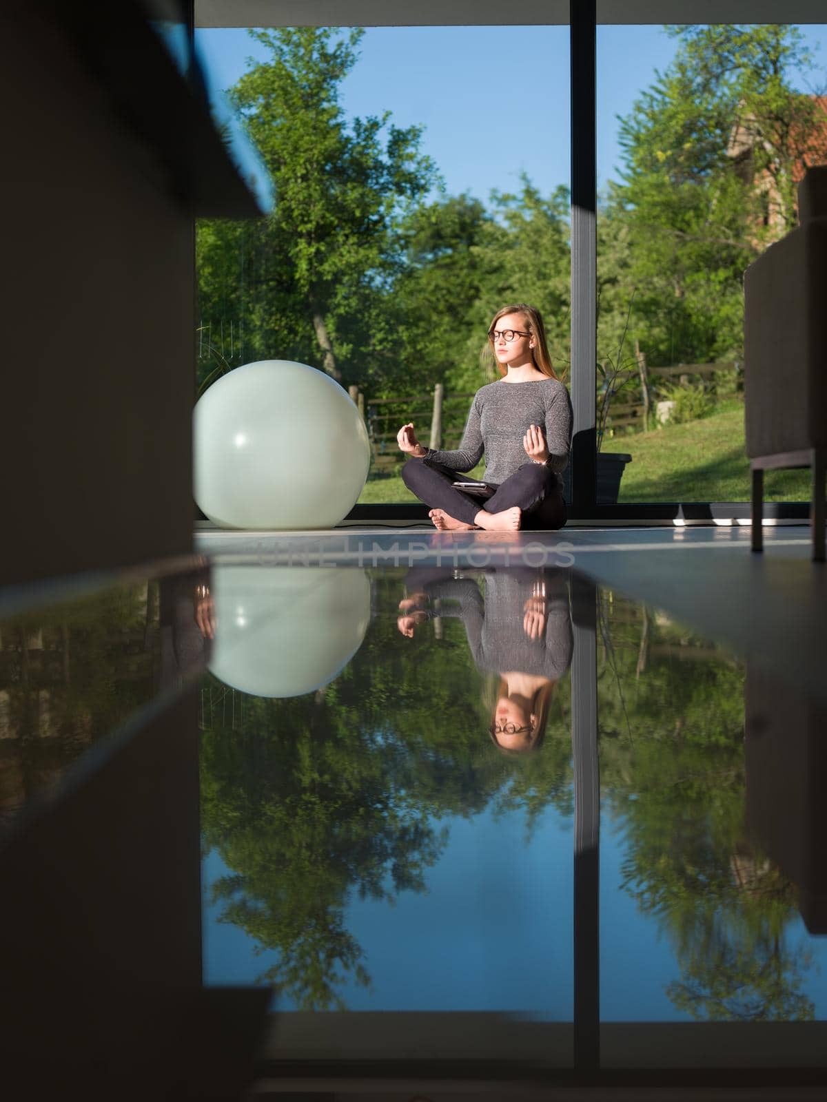 A young handsome woman doing yoga exercises on the floor of her luxury home villa