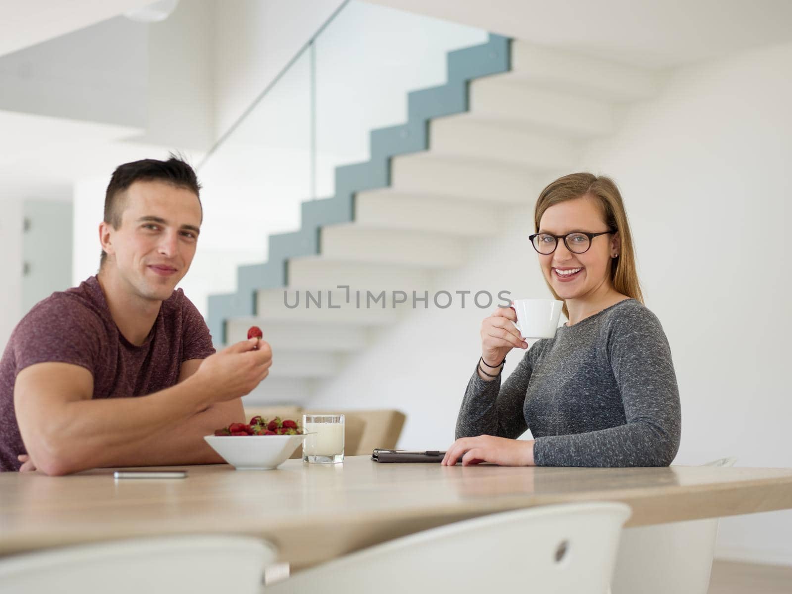 couple enjoying morning coffee and strawberries by dotshock