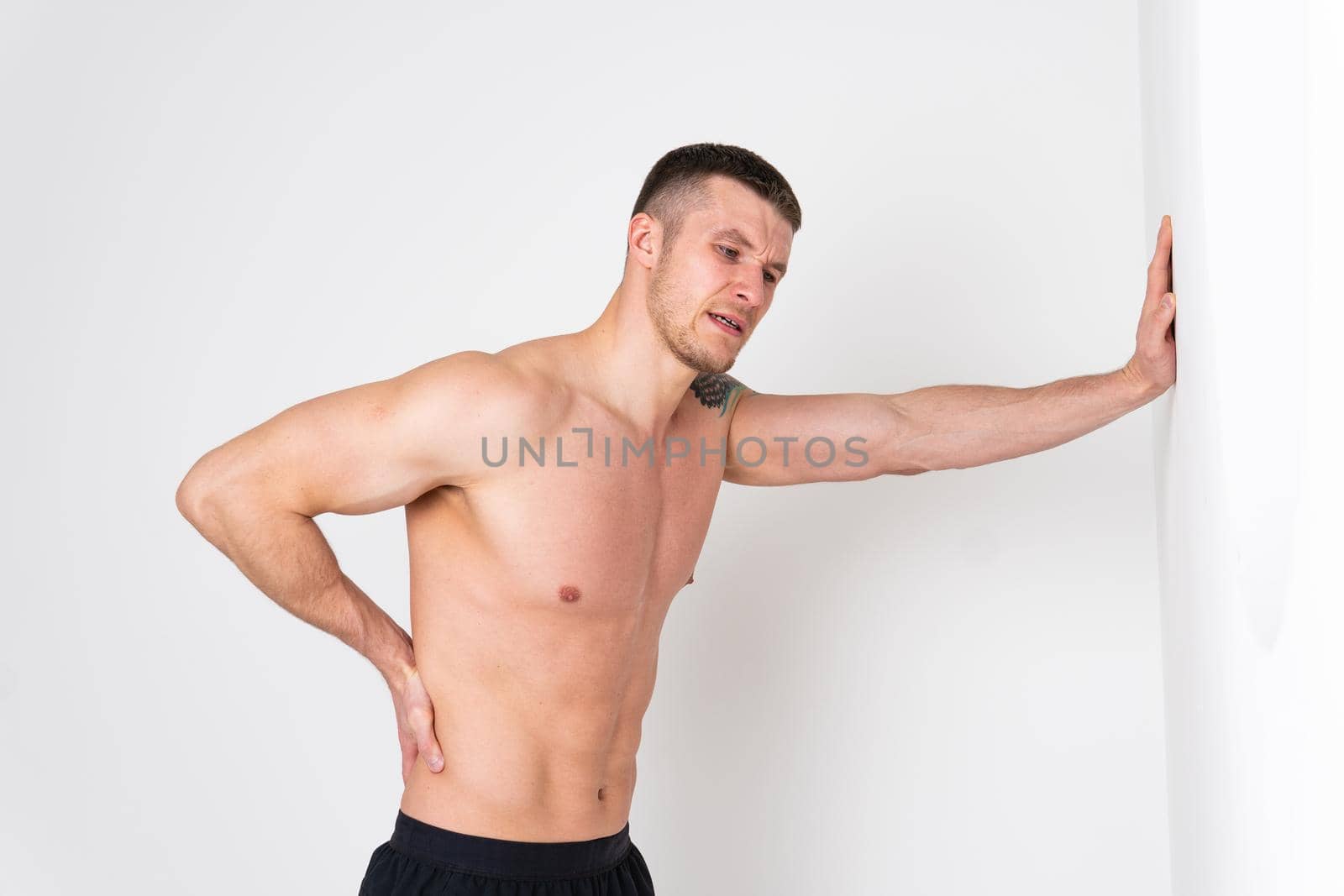 A man back pain keeps his hand on his back back hurt painful, backache male massage stress, muscular expression. Touching red disease suffer attractive by 89167702191