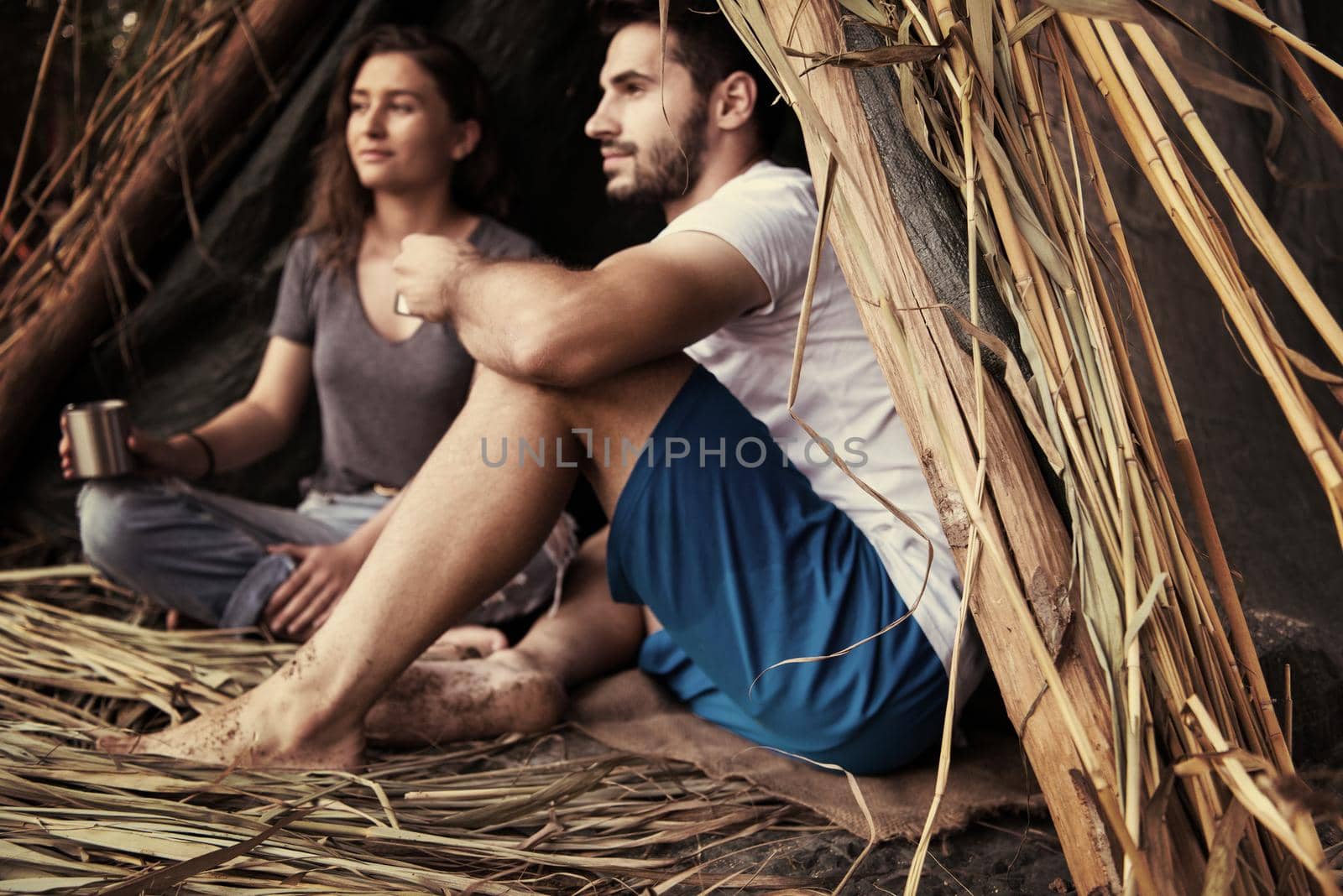 couple spending time together in straw tent by dotshock