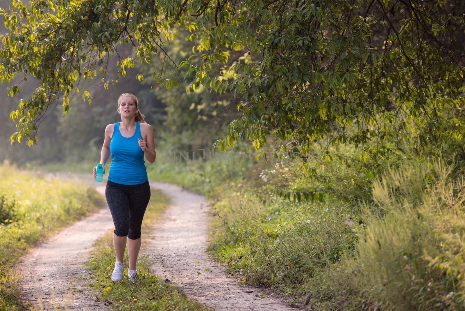 woman jogging along a country road by dotshock